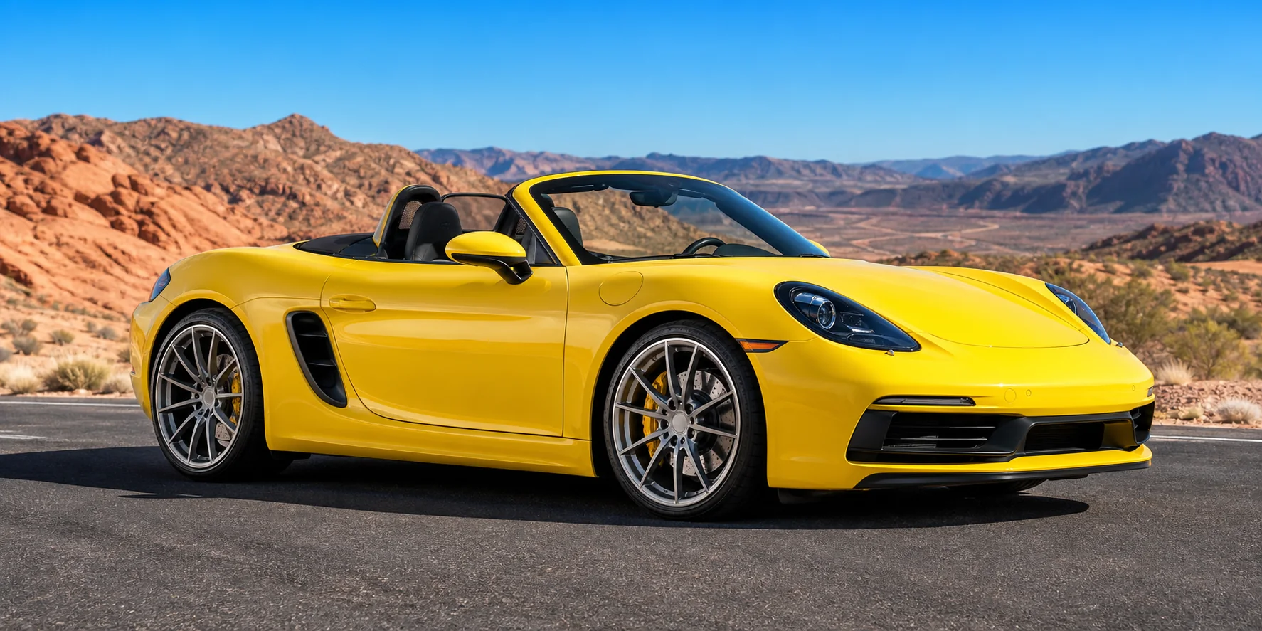 Complete glossy yellow Porsche Boxster style sports car with racing wheels and clear mountain backdrop